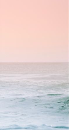 a person riding a surfboard on top of a wave in the ocean at sunset