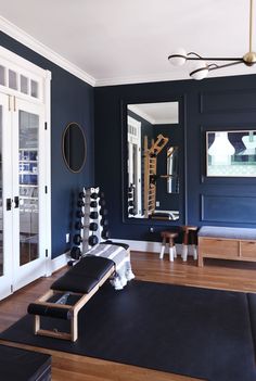 a living room with blue walls and wooden floors is pictured in this image, there is a black rug on the floor