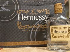 a bottle of hennessy gin is sitting on a counter next to a box