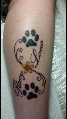 a dog's paw and name tattoo on the leg with an orange flower in it