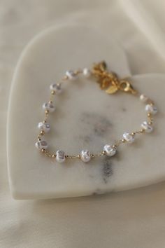 Our Pearl Station Chain Bracelet is a beautiful bracelet made out of faux nugget pearls delicately placed between strands of twinkling station chain. This bracelet is perfect for adding a touch of pearl to your gold stack. Materials: 24kt gold plate brass, faux pearls Length: approximately 8" including extender SKU: B1216 Materials + Care Gold And Pearl Bracelet, Cora Hale, Silver Prom Dress, Pearl Bracelets, Kids Bracelets, Studded Necklace, Kids Necklace, Stiles Stilinski, Older Sister