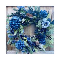 a wreath with blue flowers and pine cones