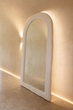 an arch shaped mirror sitting in the middle of a room