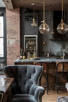 an industrial style kitchen and living room with exposed brick walls, black cabinets, gray velvet chairs, gold pendant lights and bar stools