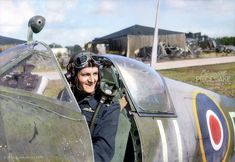 a man sitting in the cockpit of an air plane with his pilot's helmet on