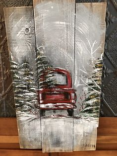 a wooden sign with a red truck in the snow and trees on it's side