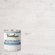 a can of whitewash sitting on top of a wooden floor next to a wall