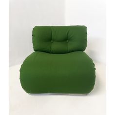 a green reclining chair sitting on top of a white floor