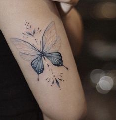 a woman's arm with a butterfly tattoo on the left side of her arm