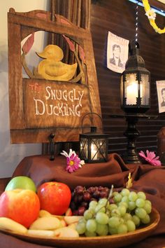 a wooden sign that says the snuggley ducking surrounded by fruit