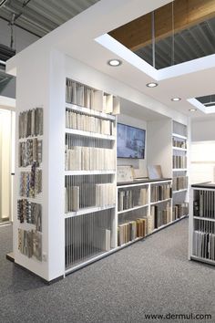 a large book case filled with lots of books on top of a white shelf next to a window