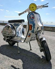 an old scooter is parked on the side of the road with no wheels