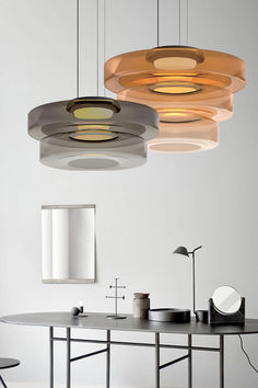 three circular lights hanging from the ceiling above a table