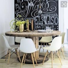 a chalkboard wall in the corner of a dining room with chairs and a table