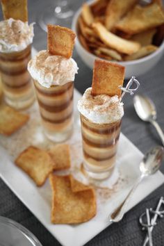 two dessert cups filled with ice cream and cinnamon sprinkles on a white plate