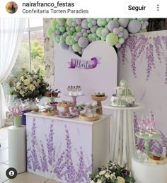 an image of a dessert table with purple and green decorations on the wall behind it