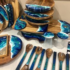 a table topped with wooden spoons and plates covered in blue marbled art work