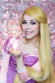 a woman with long blonde hair holding a sparkle ball