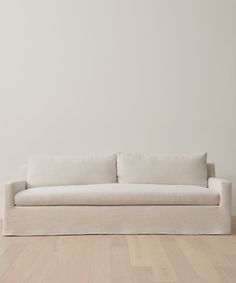 a white couch sitting on top of a hard wood floor