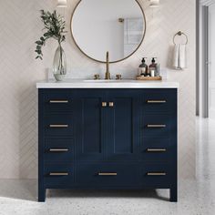 a bathroom vanity with a round mirror above it and blue cabinetry on the side