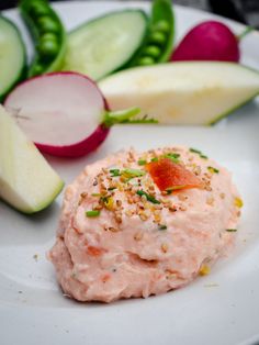 a white plate topped with cucumbers, radishes and other food items