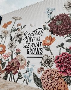 a large mural on the side of a building with flowers painted on it's sides