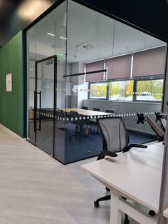 an empty conference room with glass walls and chairs