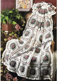 a white crocheted blanket sitting on top of a chair