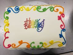 a birthday cake with the word happy written on it and colorful swirls in the frosting