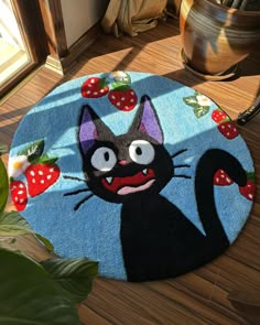 a door mat with a black cat and strawberries on it