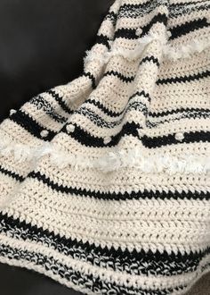 a black and white crocheted blanket sitting on top of a couch