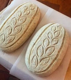 two round breads sitting on top of a piece of white paper next to each other