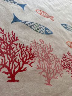 an image of a bed with corals and fish on the coverlet or comforter