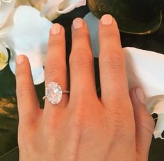 a close up of a person's hand with a diamond ring on their finger