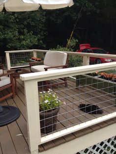 an outdoor deck with chairs and potted plants