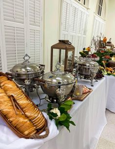 a buffet table with bread and other food items on it, including croissants