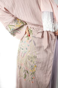 This Dusty Pink Floral Embroidered Abaya is perfect for any modern fashionista. Showcasing a beautiful faded pink with delicate embroidered floral detail, this Abaya will make you stand out in any occasion. This eye-catching mauve abaya is made of high quality textured fabric with floral embroidery along the sleeves and along the side of the abaya. The Floral Embroidered Abaya features buttons and a belt, providing you with the versatile options to wear it open or closed, tied or loose. Matching Spring Cotton Kimono With Floral Embroidery, Traditional Long Pink Abaya, Traditional Pink Maxi Length Abaya, Modest Maxi Length Kaftan For Spring, Modest Maxi-length Kaftan For Spring, Long Embroidered Dress With Floral Embroidery For Eid, Long Embroidered Dress With Floral Design For Eid, Long Floral Embroidered Dress For Eid, Long Floral Embroidered Kimono For Spring