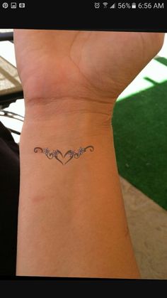 a woman's wrist with a small tattoo on it