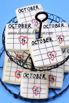 a basket filled with lots of small white tiles covered in black string and red hearts