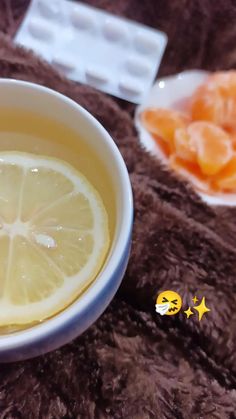 a bowl filled with lemon slices next to an ice cube and some candies on a table