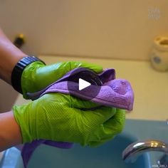 a person wearing green gloves is washing their hands