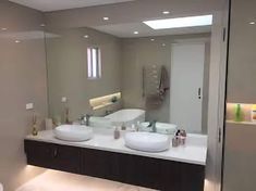 a bathroom with two sinks and a large mirror