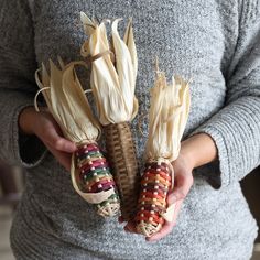 two corn cobs are being held in their hands