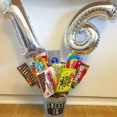 a bucket filled with candy and foil balloons