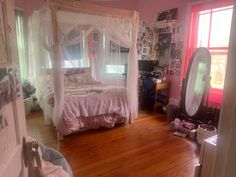 a bedroom with pink walls and wooden floors