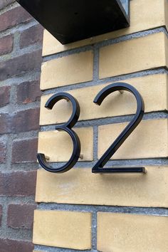 the number twenty three is mounted on a brick wall