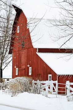 a red barn in winter with snow on the ground