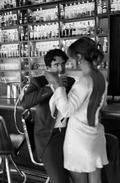 a man and woman standing in front of a bar