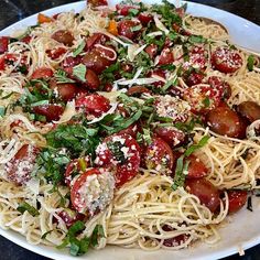 a white plate topped with spaghetti and tomatoes