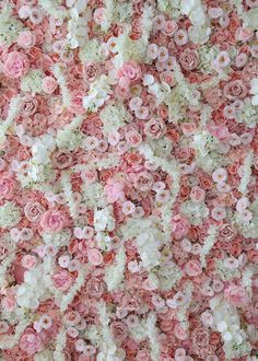 pink and white flowers are arranged in the shape of a flowery pattern on a wall